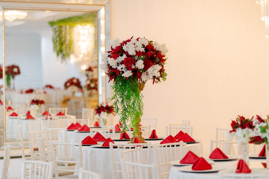 Elegant wedding reception with red and white flowers.