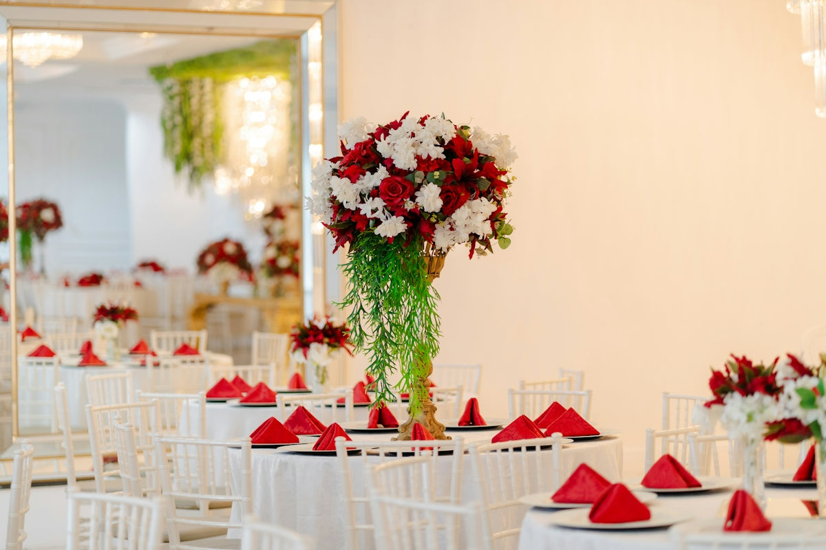 Elegant wedding reception with red and white flowers.