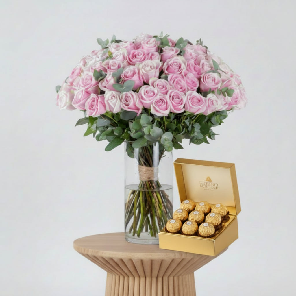 Bouquet of pink roses in a clear vase with a pink ribbon on a white background