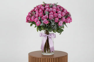 Bouquet of pink roses with a white ribbon on a light background