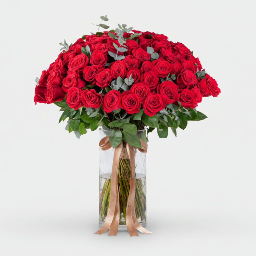 Bouquet of red roses in a clear vase on a white background