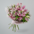 Bouquet of pink and white flowers with green leaves on a light gray background