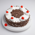 Chocolate cake with white frosting, chocolate shavings, and red cherries on a white background