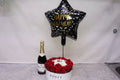 Bottle of champagne, bouquet of red roses, and 'Happy New Year' balloon
