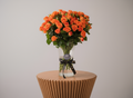 Bouquet of orange roses in a clear vase on a white background