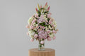 Bouquet of pink and white flowers in a clear vase on a white background