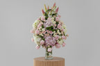Bouquet of pink and white flowers in a clear vase on a white background