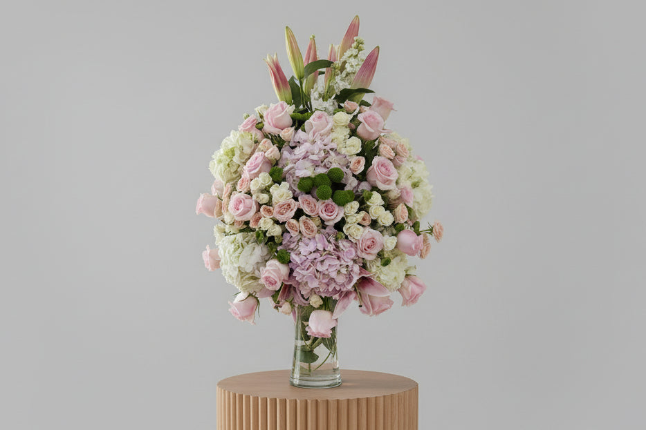 Bouquet of pink and white flowers in a clear vase on a white background