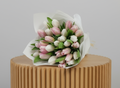 Bouquet of pink and white tulips in a white wrap on a light background