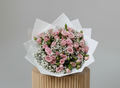 Bouquet of pink roses with gips on white wrapped paper