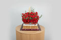 Bouquet of red roses with a tray of chocolates on a white background