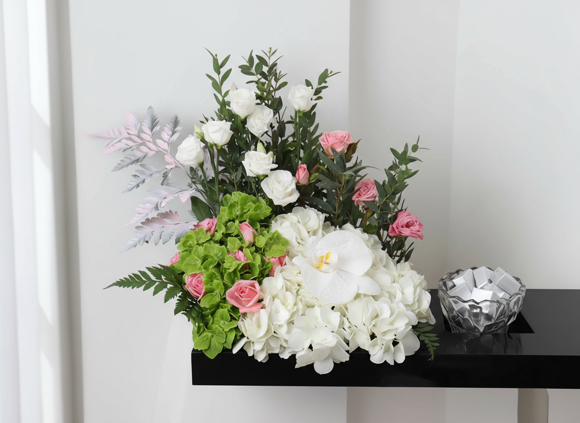 Bouquet of white and pink flowers with greenery on a black surface.