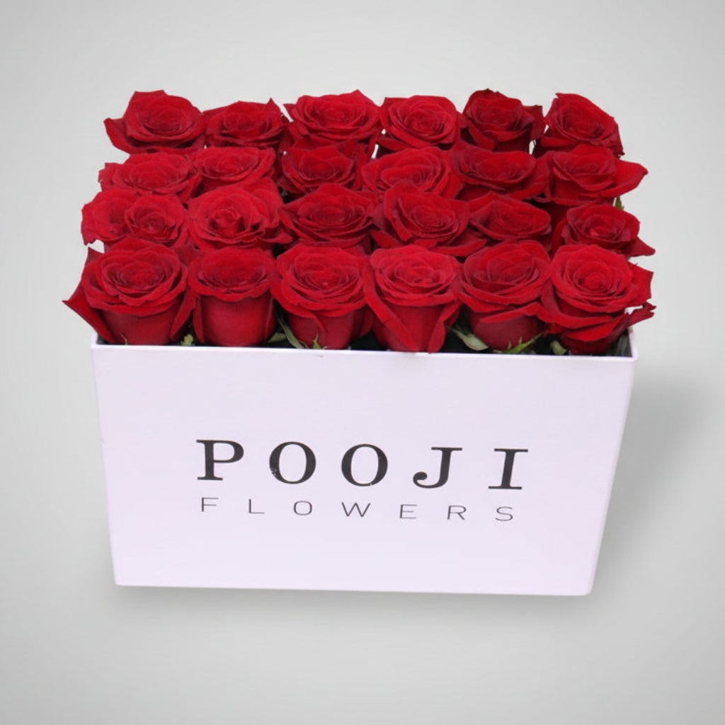 Box of red roses from POOJI Flowers on a light background