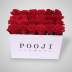 Box of red roses from POOJI Flowers on a light background