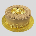 Chocolate cake with white flowers on a gold plate against a white background