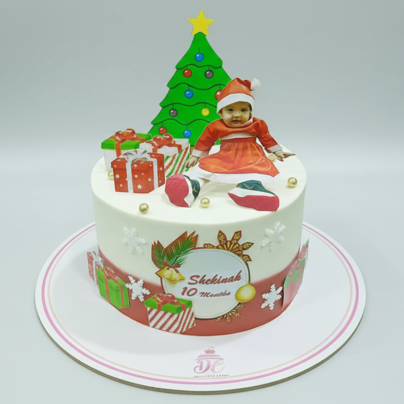 Christmas-themed birthday cake with a child figurine and decorations on a white background