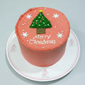 Christmas-themed cake with a tree decoration and 'Merry Christmas' text on a white background.