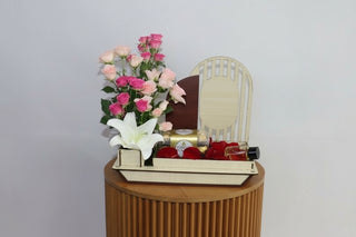 Gift basket with flowers, chocolates, and perfumes on a white background