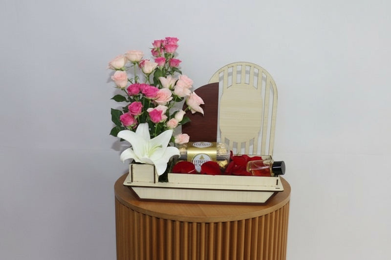 Gift basket with flowers, chocolates, and perfumes on a white background