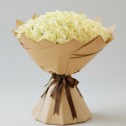 Grand bouquet of 100 white roses wrapped in elegant kraft paper with brown ribbon - luxury flower arrangement Kuwait