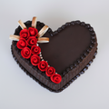 Heart-shaped chocolate cake with red roses and white ribbons on a white background
