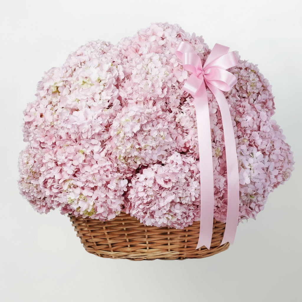 Basket of pink flowers with a pink ribbon on a white background