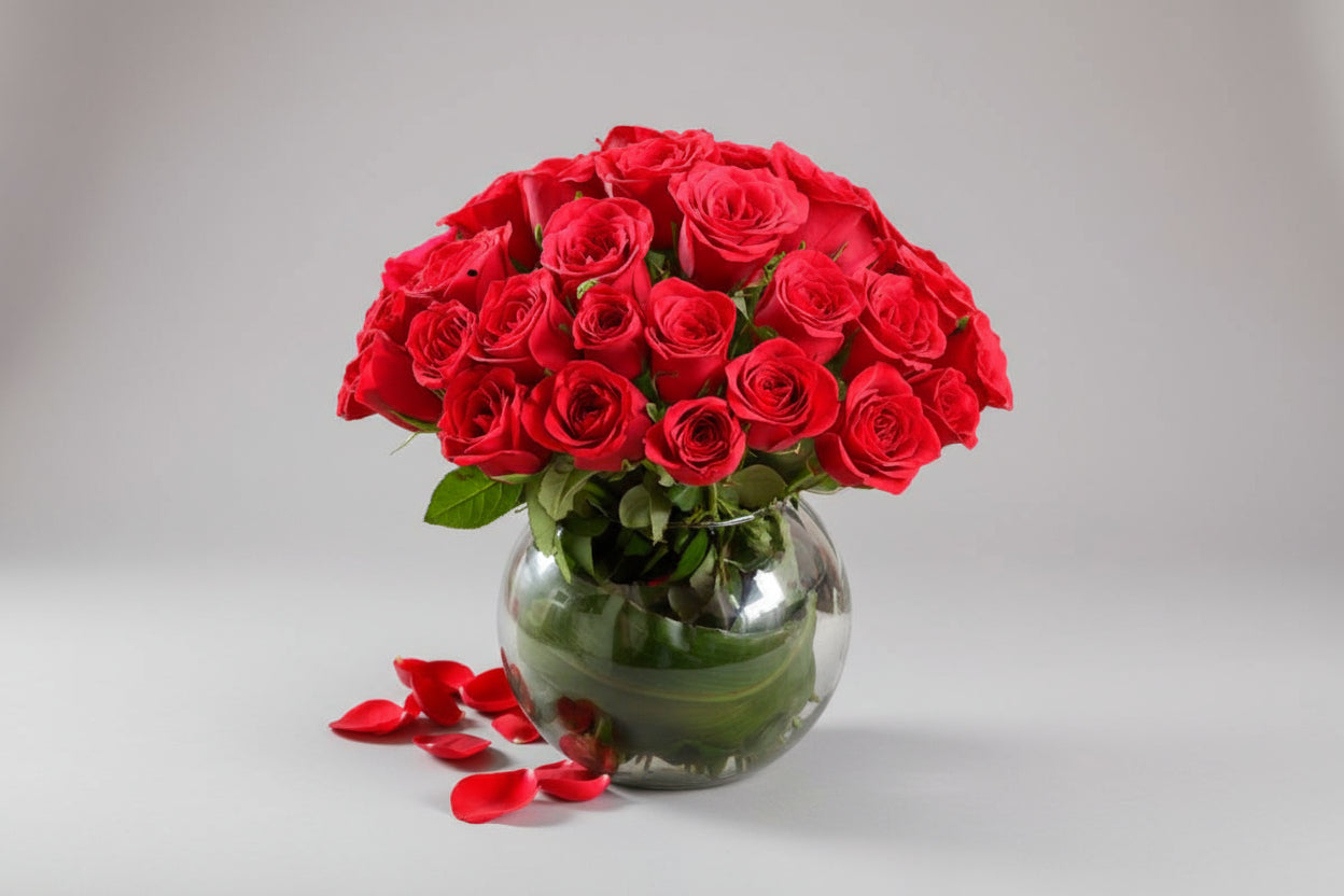 Bouquet of red roses in a clear vase on a white background