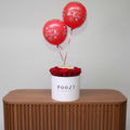 Red balloons with 'Happy Birthday' text and red roses in a white box