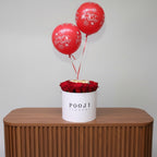 Red balloons with 'Happy Birthday' text and red roses in a white box