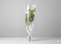 Bouquet of white roses in clear cellophane with a gold card on a gray background