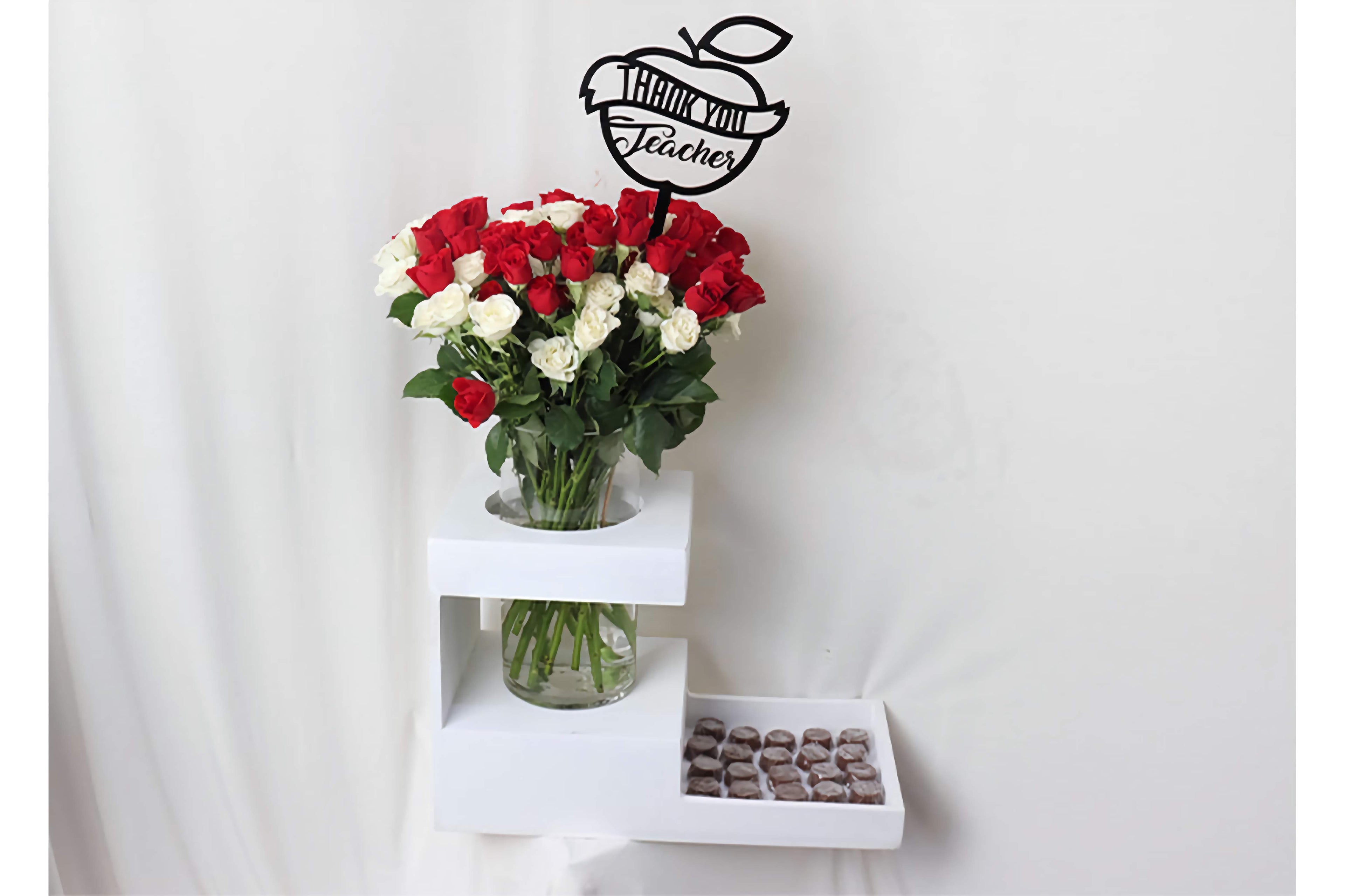 Bouquet of red and white roses on a small white table with a thank you teacher acrylic stick above in White Wood Tray.