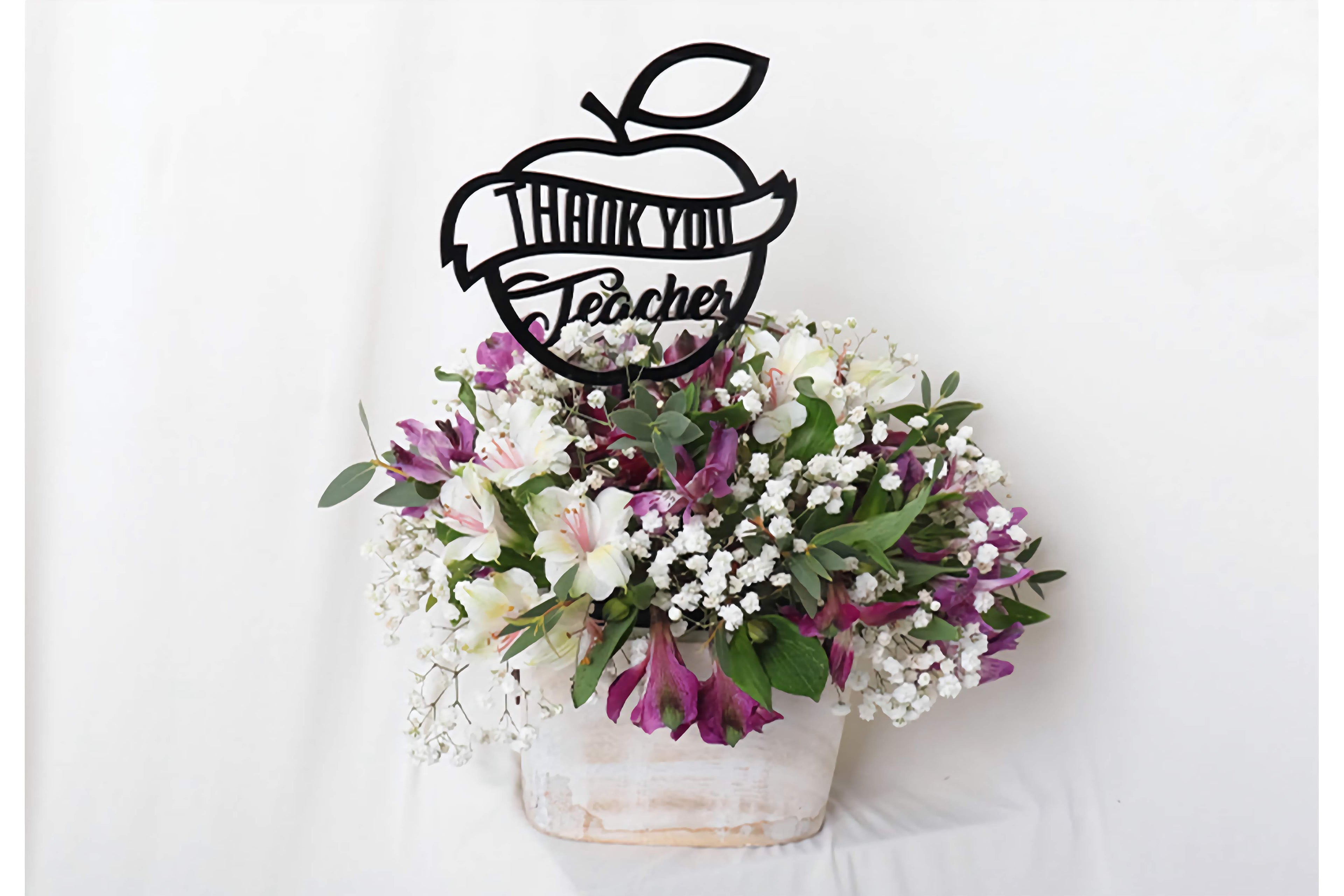 Floral arrangement with a 'Thank You Teacher' decorative piece on a white background