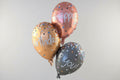 Three metallic balloons with 'Happy Birthday' text