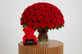 Centered 100 red roses arrangement with teddy bear