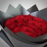 Close-up of red roses in a 25 rose hand bouquet with black wrapping