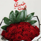 Close-up of red roses with decorative heart topper
