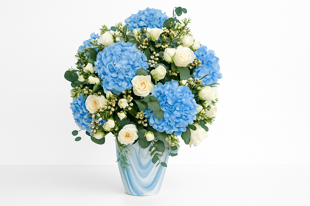 Bouquet of blue hydrangea and white rose flowers in a vase on a white background