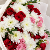 Close-up of white blooms and red and pink roses in the mixed flower bouquet