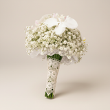 White gypsophila and Phalaenopsis orchid bridal bouquet on a warm white background