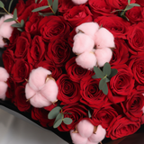 Close-up detail of red roses and pink cotton in the bouquet