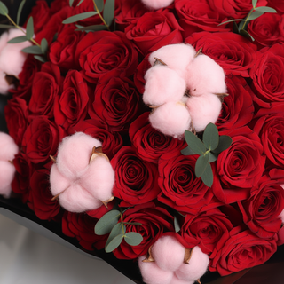 Close-up detail of red roses and pink cotton in the bouquet