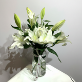 Small Casablanca flower on a plain light grey background
