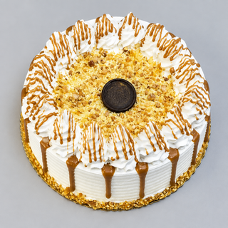 Top view of butterscotch cake with chocolate disc and praline