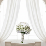 White gypsophila and Phalaenopsis orchid bridal bouquet in an elegant wedding setting