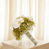 Yellow gypsophila and white Phalaenopsis orchid bridal bouquet in an elegant wedding setting