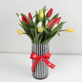 Mix Tulip Hand Bouquet featuring vibrant red, yellow, and white tulips in a striped vase