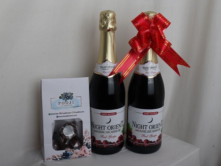 Two bottles of Night Orientale wine with a red bow, a box, and a glass on a white surface.