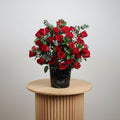 Premium Red Roses in Black Marble vase with green foliage and white fillers for elegant floral arrangements