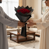 Red rose hand bouquet being presented as a gift in a warm home setting