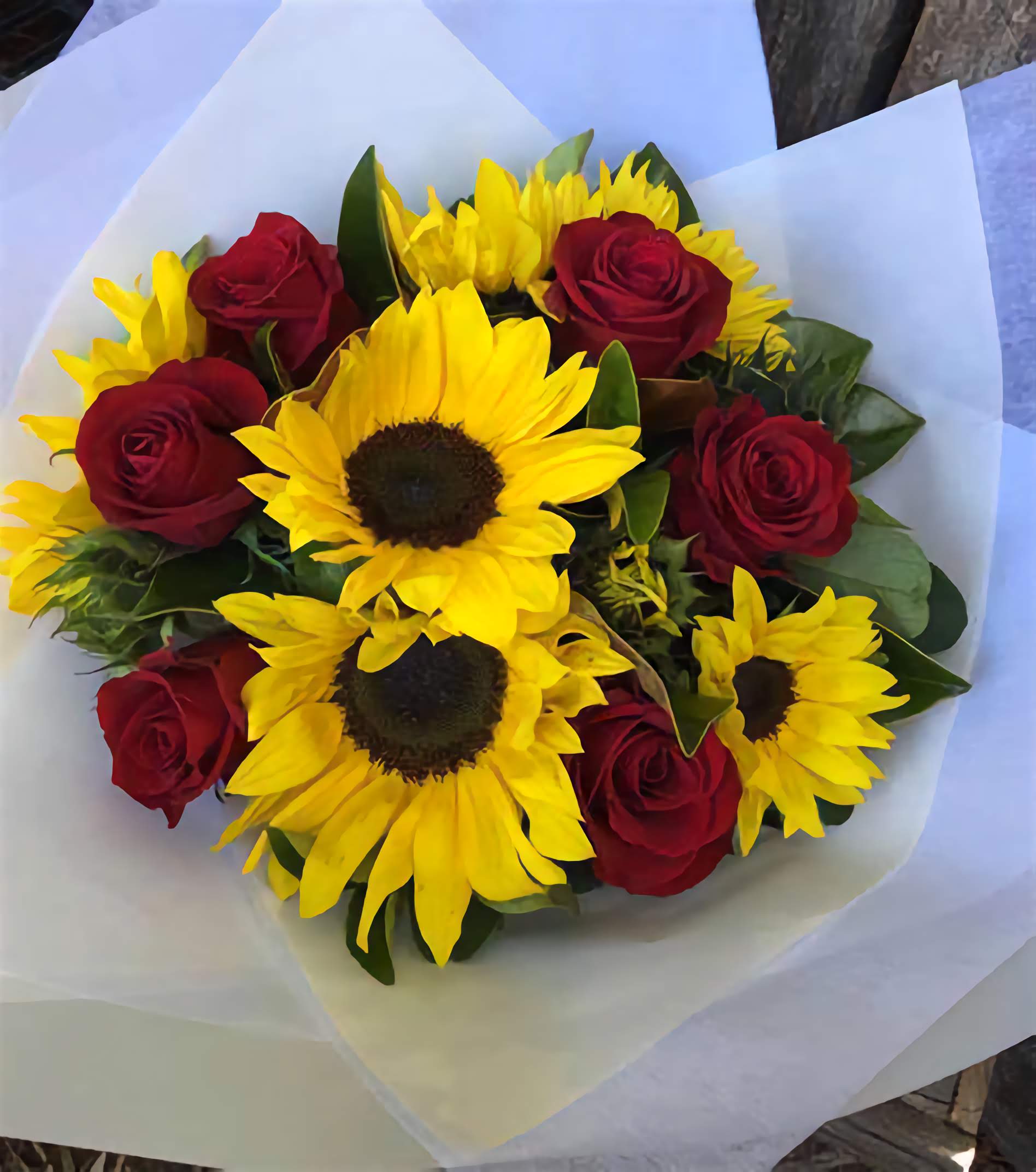 Bright bouquet of sunflowers with green foliage, featuring Red Rose Sunflower arrangement by Pooji Flowers